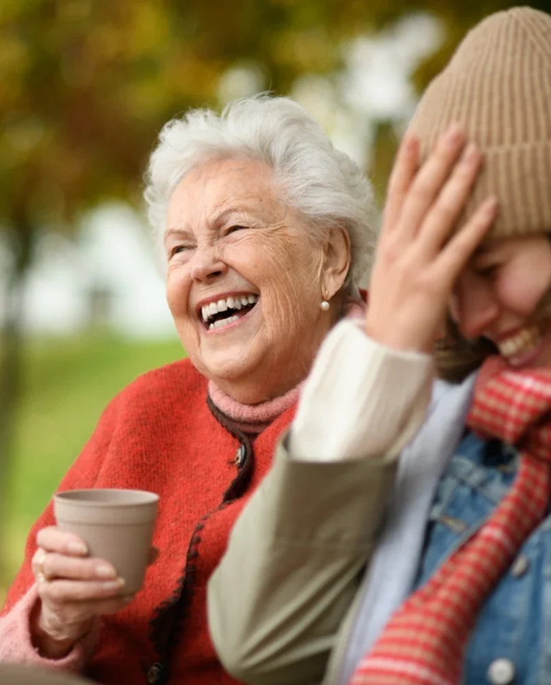 Senior woman laughing outdoors with companion care in Glen Ellyn caregiver